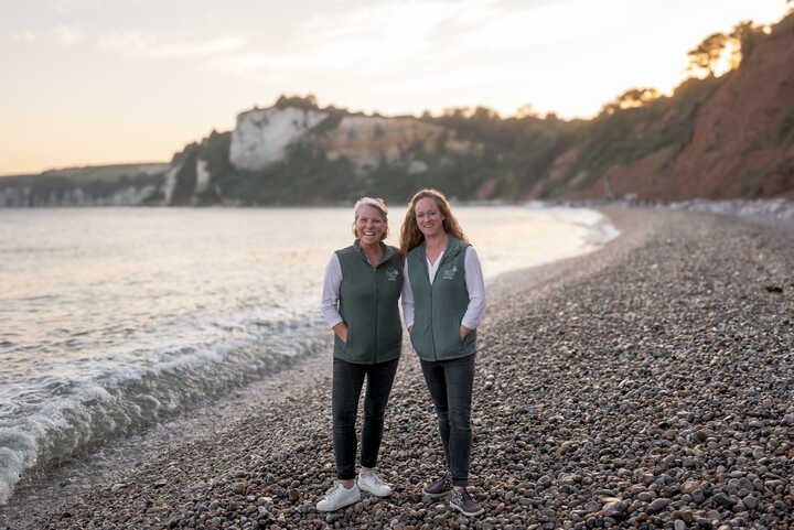 Amber and Laura of Pure Sage Holidays, stood on the beach